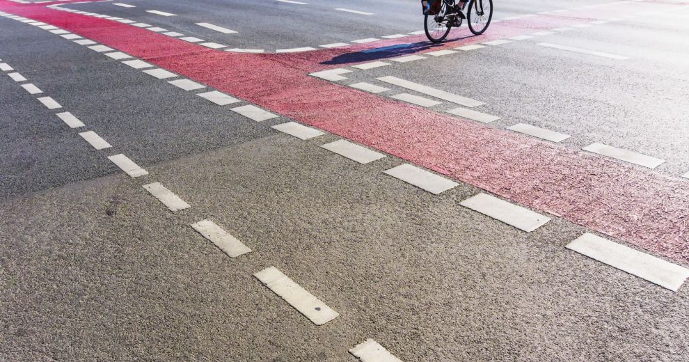 Blick auf eine Straße mit Fahrbahnmarkierungen für Fahrradspuren