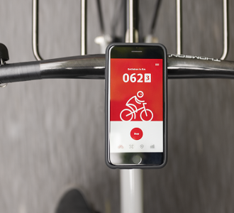 Blick auf ein am Fahrrad befestigtes Smartphone mit der geöffnete App von DB Rad+