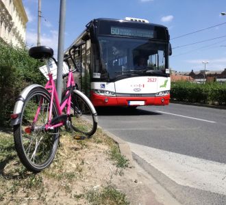 Ein Fahrrad steht an einer Straße, ein Bus im Hintergrund