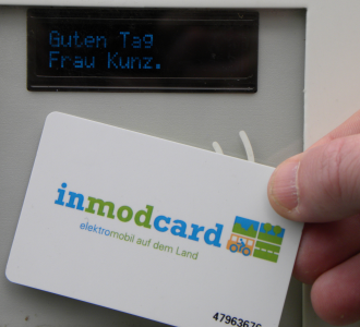 Kundin hält inmod-Nutzerkarte an Kartenlesegerät.